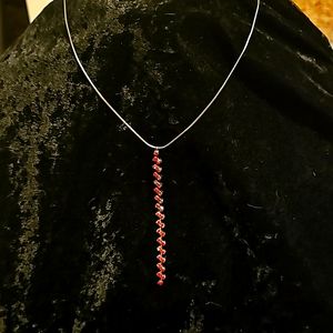 Ladies Necklace on Black chain with red Rinestones hanging down.